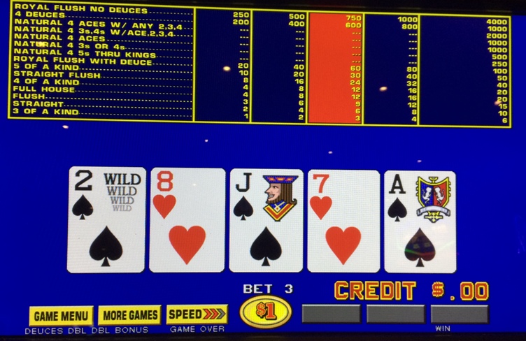 Video poker machine screen displaying a Deuces Wild game. The top shows a paytable for various hands. The bottom shows a dealt hand of 2♠ (Wild), 8♥, J♠, 7♥, A♠. The bet is 3 credits with $0.00 credit remaining.